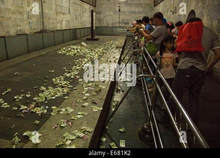 Beijing, China. 14th Aug, 2014. AUGUST 14: People throw small change to the coffin bed as they pray for a better future at the underground palace of Dingling Tomb, the mausoleum of Emperor Zhu Yijun (1563 - 1620) of Ming Dynasty, on August 14, 2014 in Beijing, China. © SIPA Asia/ZUMA Wire/Alamy Live News Stock Photo