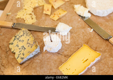 Homemade cheeses cheese knives on cutting board at Farm House Natural Cheeses factory, Agassiz, British Columbia, Canada. Stock Photo