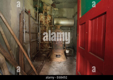 Old boiler in storage room, to heat water for the former creamery at Santanoni Preserve, New York. Stock Photo