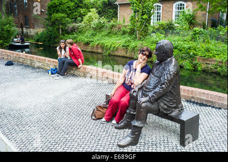 A tourist poses with the Statue of Dave Lee who was local Canterbury Comedian and Pantomime Dame. Stock Photo