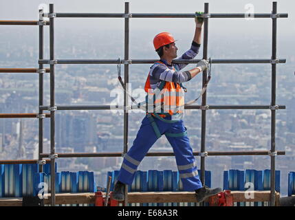 Moscow, Russia. 18th Aug, 2014. A construction worker carrying scaffolding at the Federation Tower skyscraper at the Moscow International Business Centre (MIBC), or Moscow City. Credit:  Mikhail Metzel/ITAR-TASS/Alamy Live News
