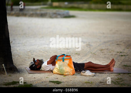 Miami in Florida USA a man sleep on the beach area around Ocean Drive. Stock Photo