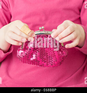 Hand of little girl holding pink change purse Stock Photo
