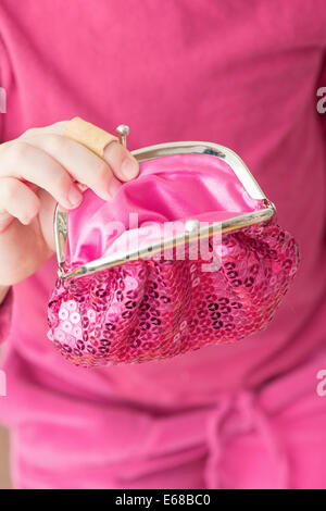 Hand of little girl holding pink change purse Stock Photo