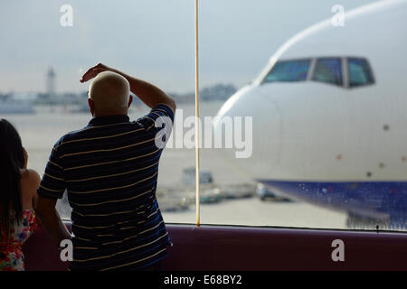 Passenger looking through the glass at Ransaero Airlines plane Beoing 777 Stock Photo