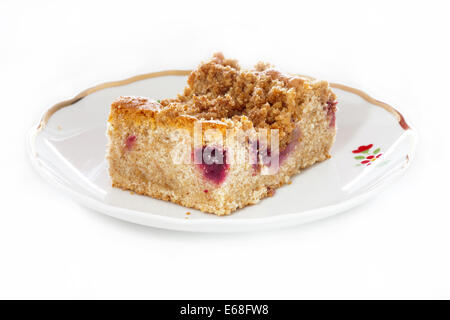One piece of fresh Plum crumble cake on a plate isolated on white Background Stock Photo