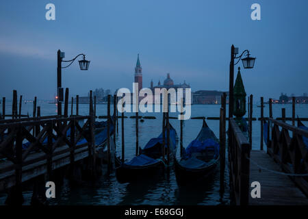 Dawn on the waterfront of Venice with gondolas looking toward the Church of San Giorgio Maggiore across the Lagoon. Stock Photo