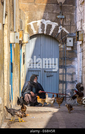 An old Kurdish-Turkish man, sitting in an alley of the old city of Sanliurfa, also known as Urfa, Southeastern Anatolia, Turkey Stock Photo