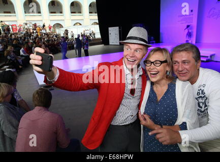 Moscow, Russia. 18th Aug, 2014. Actors Alexander Kuznetsov, Natalya Khorokhorina and Ivan Shabaltas (L-R) take a selfie photograph at the 12th International Specialized Exhibition of Headwear Raw Materials and Accessories 'Chapeau 2014', at Moscow's Gosti