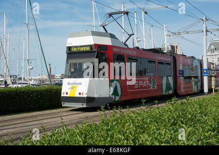 A tram operated by De Lijn leaves Ostend station and heads towards Westends Bad on the coastal tramway route Stock Photo