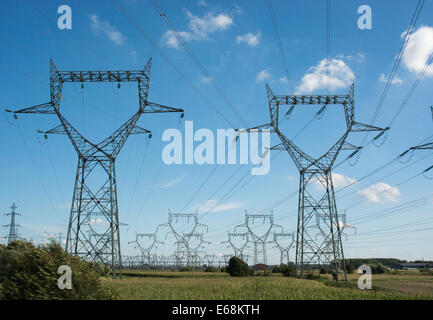 Pylons carrying high voltage power lines march across the French countryside. Stock Photo