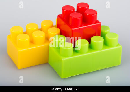 Three plastic building blocks isolated green yellow red Stock Photo