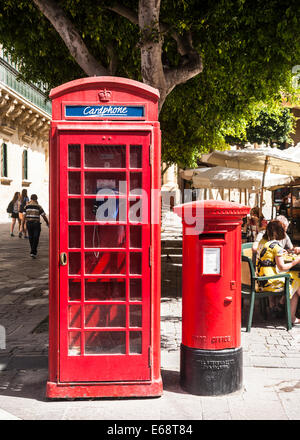 Old red British phone and post boxes together on a Valletta street, Malta. Stock Photo