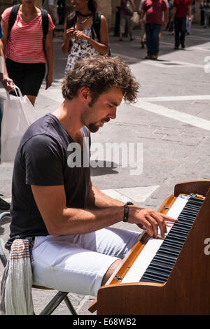 A man busking playing a piano on a Valletta street, Malta. Stock Photo