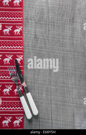 Knives and forks on wooden xmas background in red for a menu card. Stock Photo