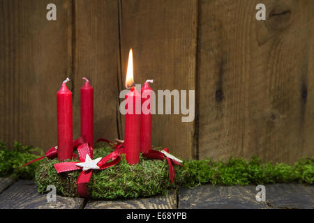 Advent or christmas wreath with four red wax candles on wooden background. Stock Photo