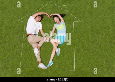 Young couple lying on grass in an artificial house Stock Photo