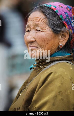 Elderly woman, portrait, wearing a traditional deel, in the Buddhist Gandan Monastery, Ulaanbaatar, Mongolia Stock Photo