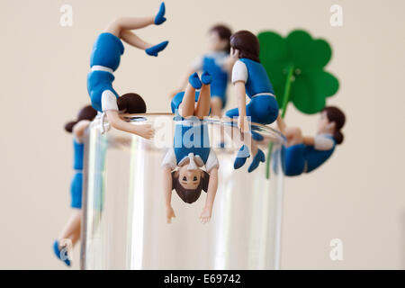 Different kinds of 'Cup no Fuchiko' climb on the side of a glass on August 19, 2014 in Tokyo, Japan. These mini figures are popular amongst young Japanese women who often use them when composing pictures of their lunch. The name Cup no Fuchiko translates to  or 'office lady, or OL, on the side of a cup' and the figures are sold as drink ornaments. Made by  Kitan Club CO. LTD Cup no Fuchiko was created by the manga artist Katsuki Tanaka. There are currently 21 models of Cup no Fuchiko and Kitan Club has also made capsule toys from famous characters such as Street Fighter II, Moomin, Hello Kitty Stock Photo