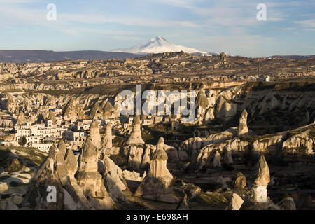 The village of Goreme in front of the snow-capped volcano Erciyes Dağı, Cappadocia, Turkey Stock Photo