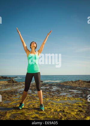 Caucasian runner smiling on beach Stock Photo