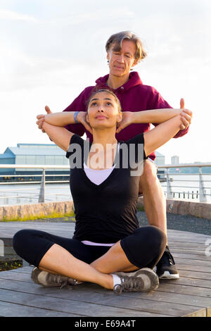 Couple exercising in waterfront park Stock Photo