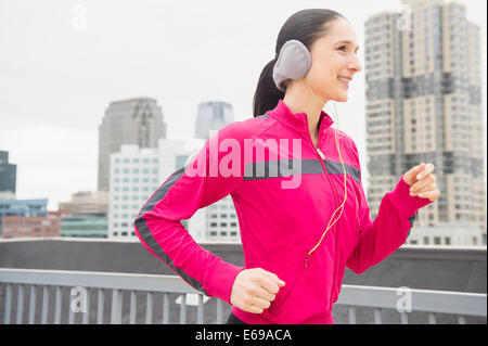 Caucasian woman jogging in city Stock Photo
