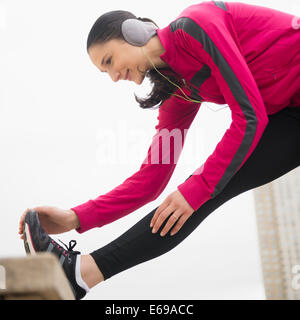 Caucasian woman stretching leg Stock Photo