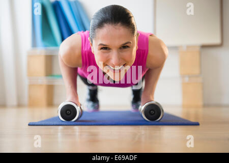 Caucasian woman doing push ups on yoga mat Stock Photo