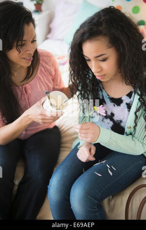 Mother comforting lovesick daughter with ice cream Stock Photo