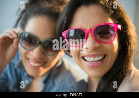 Mother and daughter wearing novelty sunglasses Stock Photo