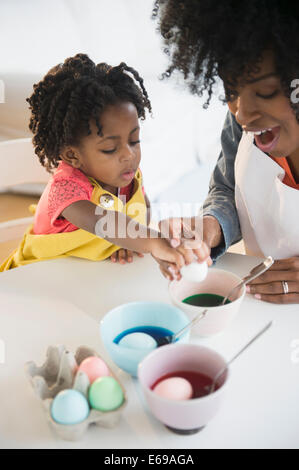 Mother and daughter dyeing Easter eggs Stock Photo