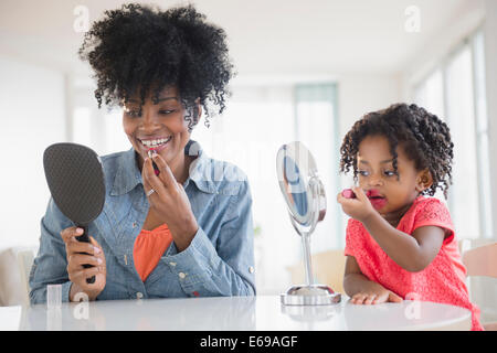 Mother and daughter applying makeup Stock Photo