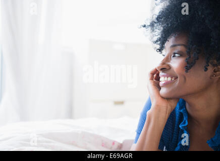 Black woman smiling on bed Stock Photo