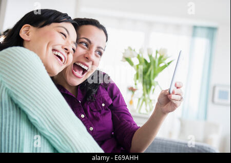 Women taking picture together in living room Stock Photo