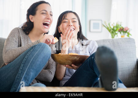 Women laughing on sofa together Stock Photo