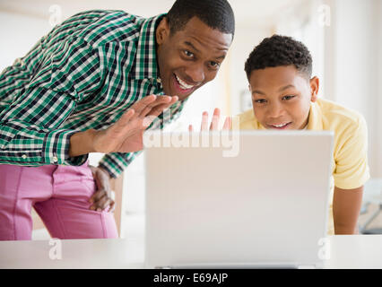 Father and son video chatting on laptop Stock Photo