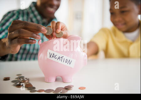 Father and son saving coins for vacation Stock Photo
