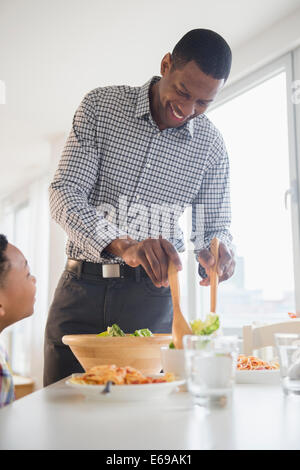 Father and son eating together at table Stock Photo