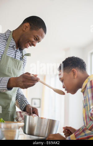 Father and son cooking together in kitchen Stock Photo