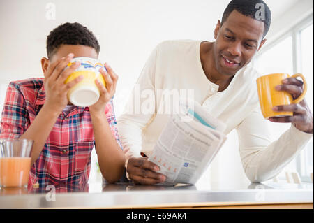 Father and son having breakfast in kitchen Stock Photo
