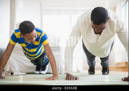 Father and son doing push ups together Stock Photo