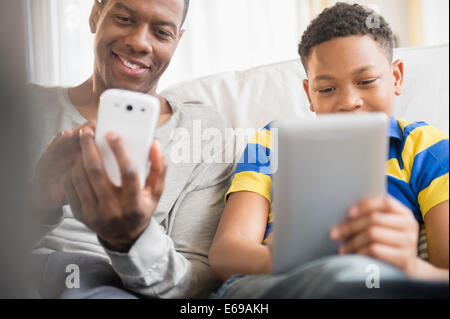 Father and son using technology together Stock Photo