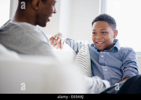 Father and son relaxing on sofa Stock Photo