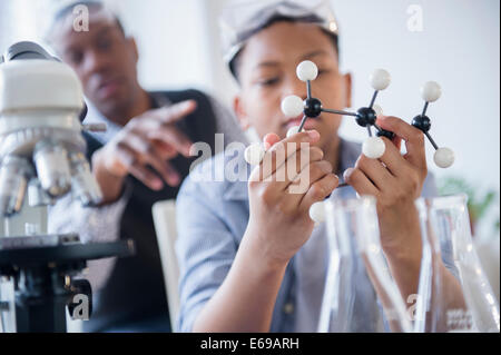 Student examining molecular model in science class