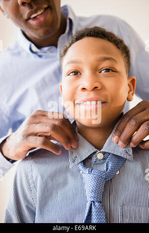 Father adjusting son's tie
