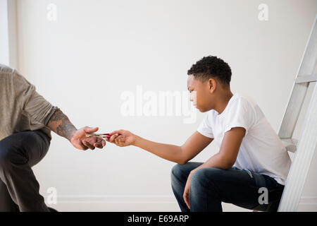 Boy giving father pliers Stock Photo