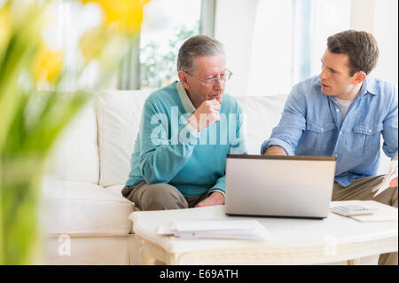 Caucasian man helping father use computer Stock Photo