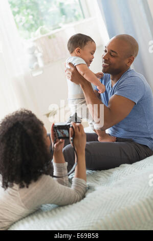 Woman taking picture of father and baby Stock Photo
