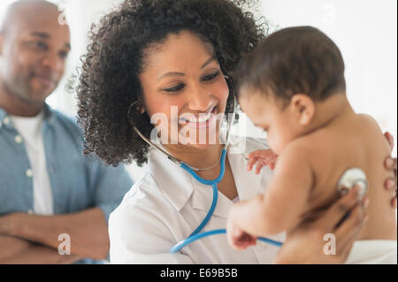 Doctor giving baby a check up in office Stock Photo
